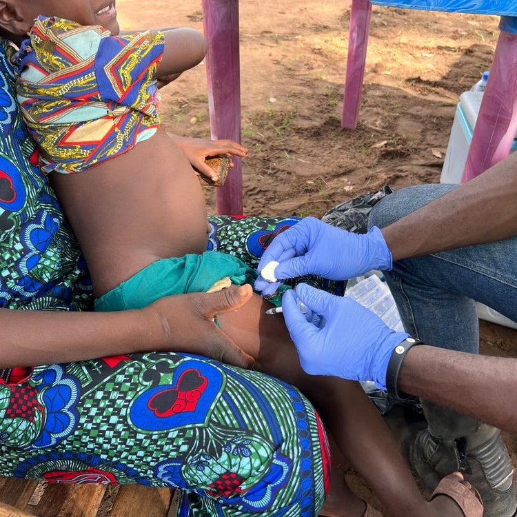 Person receiving a vaccine injection in a rural setting